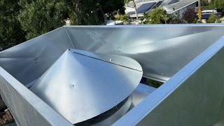 Close-up corner detail of a marine-grade galvanized chimney cap and chase cover, Bradenton Beach FL