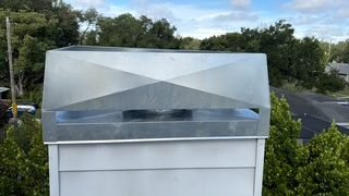 Aerial view of a large galvanized metal chase cover with a diagonal support brace on a Lakewood Ranch area home