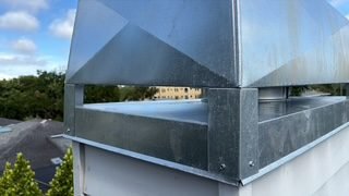 Close-up seam detail of a galvanized chimney chase cover installed on a Lakewood Ranch home
