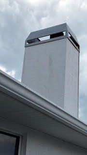 Tall modern gray chimney chase with a dark metal shroud on a newer Lakewood Ranch build