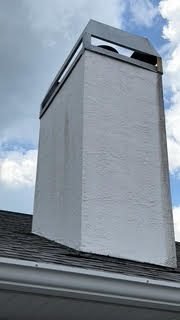 Modern white stucco chimney chase with a dark metal cap on a Lakewood Ranch home